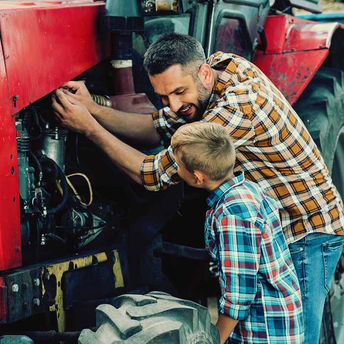 Father and son working on a farm tractor together